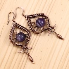 "Handmade vintage earrings; wire wrapped copper earrings with amethyst gemstone; oxidized antiqued copper wire and natural gemstone jewelry 2 1/2\" ( with a hook ) X 15/16\" ( 6.2 X 2.4 cm ) Beautiful amethyst gemstone captured in hand woven antiqued oxidized copper wire. Art Deco inspired. February birthstone. Amethyst is a meditative and calming stone which promotes calm, balance, and peace. It is also used to eliminate impatience. Amethyst is used as beneficial when dealing with legal problem Artisan Wire Wrapped Copper Earrings, Artisan Handmade Earrings In Copper Wire, Artisan Handmade Earrings With Copper Wire, Artisan Handmade Copper Wire Earrings, Artisan Copper Wire Wrapped Earrings, Artisan Handmade Earrings, Artisan Metal Earrings Wire Wrapped, Amethyst Wire Wrapped Drop Earrings, Vintage Wire Wrapped Copper Earrings