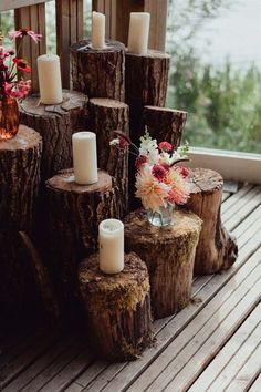 Wedding decor with tree trunks and white pillar candles with pink, red and white flowers Stump Decor, Wildflower Seed Favors, Wildflower Favors, Seed Favors, White Pillar Candles, Informal Weddings, Wedding Decorations On A Budget, Floral Embroidery Dress