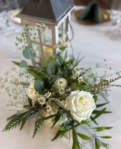 a bouquet of flowers sitting on top of a table next to a small candle holder