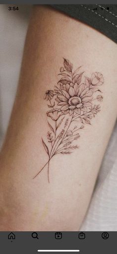 a woman's leg with a flower tattoo on the side of her arm and an arrow