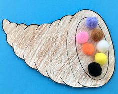 a paper plate with pom - poms on it sitting on a blue surface