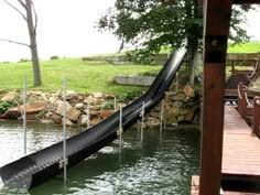 a water slide in the middle of a body of water next to a wooden dock