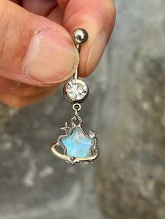 a person holding a small blue opalite and diamond dangle