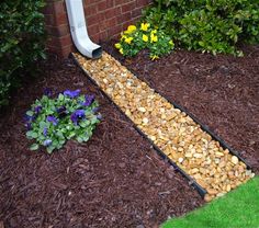 a garden path made out of rocks and mulchs next to a flower bed