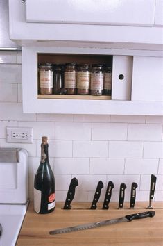 a kitchen counter with knives and bottles on it