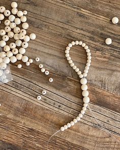 bead string and beads laid out on a wooden surface, with the word love spelled in small letters