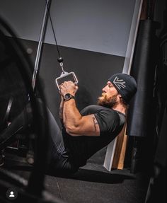 a man in black shirt and hat doing pull ups