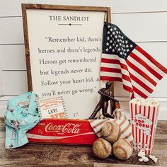 an american flag and some baseballs next to a sign that says the sandlot