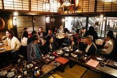 a group of people sitting at tables in a restaurant