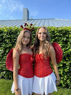 two girls dressed in costumes standing next to each other