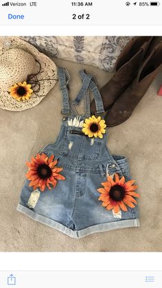 a pair of denim overalls with sunflower appliques