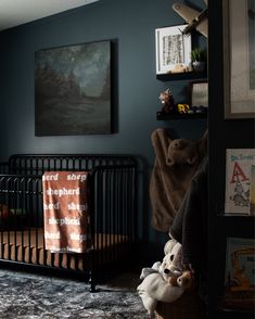 a baby's room with a crib, teddy bear and bookshelf