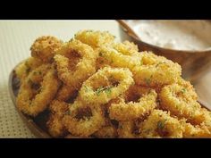 some fried food is on a plate next to a spoon