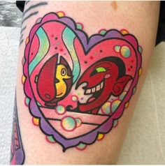 a woman with a tattoo on her leg has a heart shaped frame and two birds