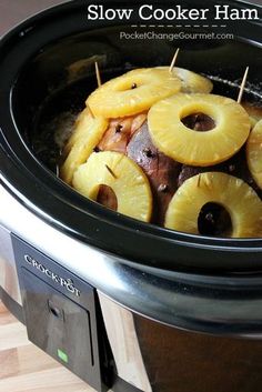 slow cooker ham with sliced pineapples and onions in the crock pot