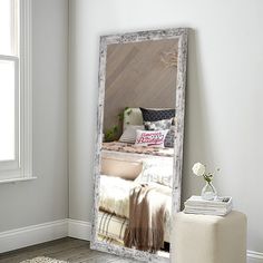 a large mirror sitting on top of a wooden floor