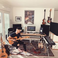 a man sitting in front of a keyboard and guitar