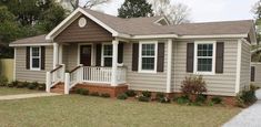 a small house with brown shutters and white trim on the front porch is shown