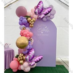 a balloon arch with balloons and butterflies on it