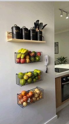 two metal baskets filled with fruit on top of a wall