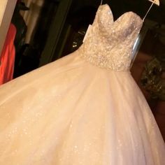 a wedding dress hanging on a hanger in front of a closet full of clothes