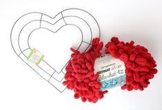 a yarn ball is next to a heart shaped paper cutout