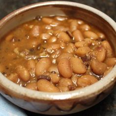 a bowl filled with beans sitting on top of a table