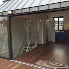 an empty room with wooden floors and glass doors