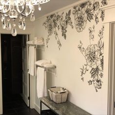 a bathroom with a chandelier hanging from the ceiling next to a wall covered in flowers