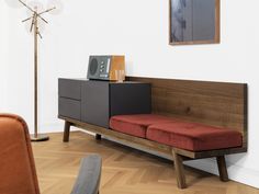 a living room with a couch, chair and sideboard