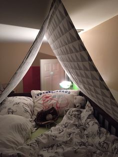 an unmade bed with white sheets and pillows