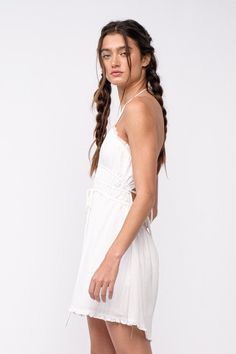 We're dreaming of a beautiful sunny day, and it starts with the Kristen White Halter Mini Dress! White woven fabric forms a cutout tie bodice with a plunging V-neckline that meets a strappy, open back and an elastic waistband. The attached mini-skirt has an elastic waist. DETAILS & CARE 80% Rayon, 20% Polyester/LINING: Polyester. Hand wash cold or dry clean. Imported. White Backless Dress With Lace-up Back For Summer, Strappy Summer Dress With Lace-up Back, Beach V-neck Dress With Lace-up Back, Vacation Halter Neck Dress With Lace-up Back, Summer Beach Backless Dress With Lace-up Back, Spring V-neck Halter Dress With Crisscross Straps, Halter Neck Dress With Lace-up Back For Day Out, Casual Summer Maxi Dress With Crisscross Straps, Chic Strappy Halter Dress With Tie Back