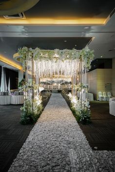 an aisle decorated with white flowers and greenery at the end of a wedding ceremony