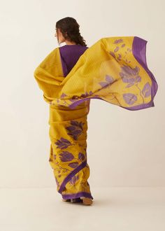 Editor's Note This mustard and purple magnolia floral silk saree is a beautiful and elegant choice for any special occasion. The saree features a delicate magnolia floral pattern in shades of mustard and purple, creating a stunning and feminine design. Note: Stitched blouse worn by model is for styling purposes only. Color: Mustard, purple Fabric: Natural silk Components: Sari and unstitched blouse piece Fit: Free size Occasion: Festive Care: Dry Clean Only About the Designer Shivani Bhargava de Yellow Cotton Silk Pre-draped Saree With Unstitched Blouse, Elegant Yellow Cotton Silk Pre-draped Saree, Elegant Yellow Cotton Silk Blouse Piece, Fitted Yellow Pre-draped Saree With Zari Weaving, Yellow Semi-stitched Cotton Silk Saree, Yellow Cotton Silk Blouse Piece Traditional Drape, Yellow Bollywood Cotton Silk Pre-draped Saree, Yellow Silk Pre-draped Saree With Unstitched Blouse, Yellow Tissue Silk Saree With Unstitched Blouse