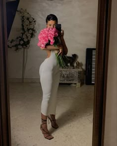 a woman taking a selfie in front of a mirror with flowers on her head