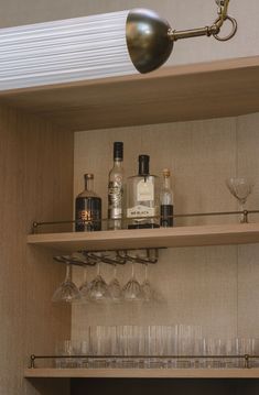 bottles and glasses are sitting on the shelves