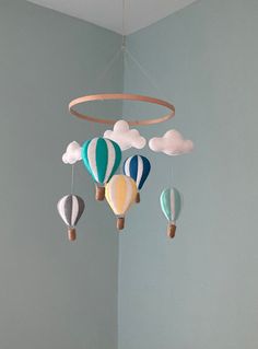 a baby crib mobile with hot air balloons hanging from it's sides in a nursery room