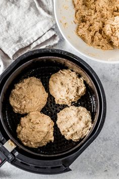 some food is cooking in an air fryer on the counter next to a bowl