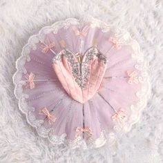 a pink heart shaped pillow sitting on top of a white furnishce covered floor