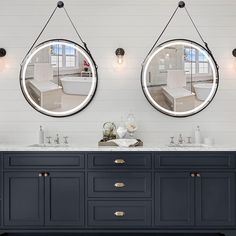 two round mirrors are hanging above the double sink vanity