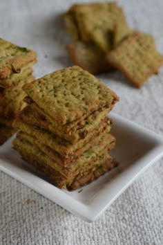 some crackers are stacked on top of each other in a square white plate,