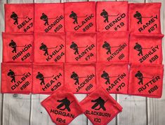 nine red towels with black and white images on them, all showing the names of different sports teams