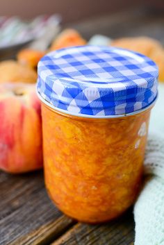 an apple and orange jam sitting on top of a wooden table