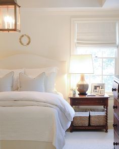 a bedroom with white bedding and pillows