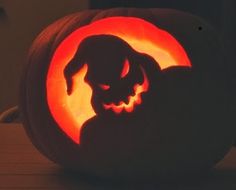 a pumpkin carved to look like a dog with its head in the shape of a pumpkin