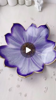 a purple flower shaped bowl sitting on top of a table