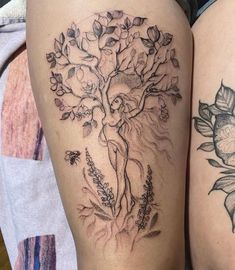 two people with tattoos on their legs, one has a tree and the other has flowers