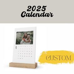 a wooden frame with a calendar on it and the words custom written in black ink