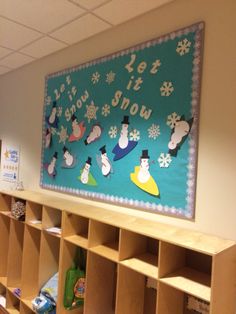 there is a snowman bulletin board on the wall in this classroom room with lots of bookshelves