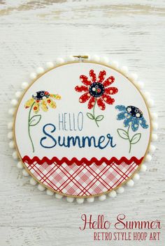 a embroidery kit with flowers and the words hello summer written in blue, red, yellow and white